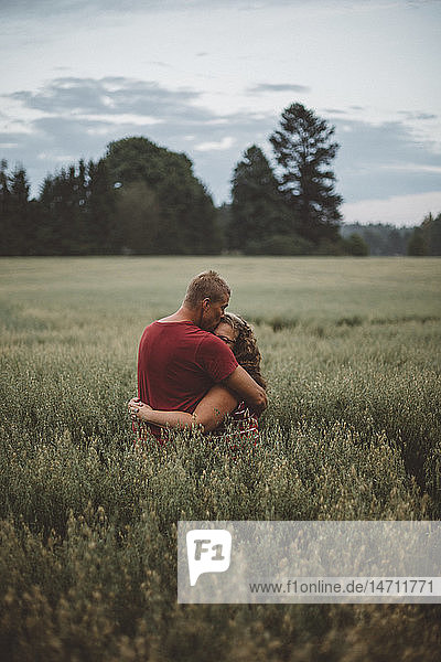 Couple hugging in meadow