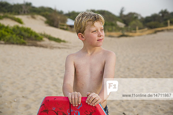 Junge am Strand schaut weg