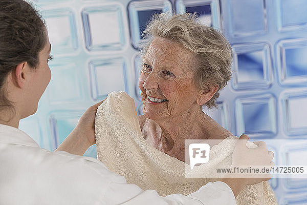 Nurse helping a senior woman to wash.