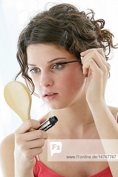 ADOLESCENT PUTTING ON MAKE-UP
