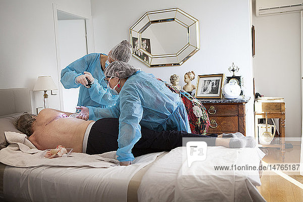 Reportage on a home health care service in Savoie  France. A nurse and auxiliary nurse place a VAC therapy dressing on a pulmonectomy.