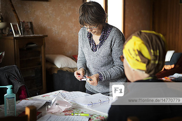Reportage über einen häuslichen Pflegedienst in Savoie  Frankreich. Eine Krankenschwester packt die Röhrchen für einen Bluttest ein  den sie gerade bei einem krebskranken Patienten durchgeführt hat.