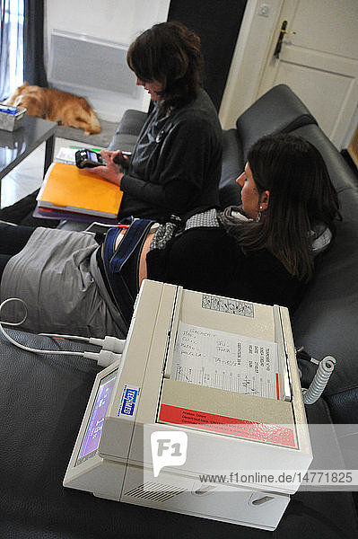 Reportage in an independent midwife practice in Ham in the Somme region of France during home visits. Carrying out foetal monitoring.