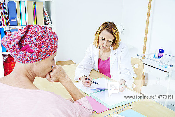 Woman suffering from cancer talking to her doctor.