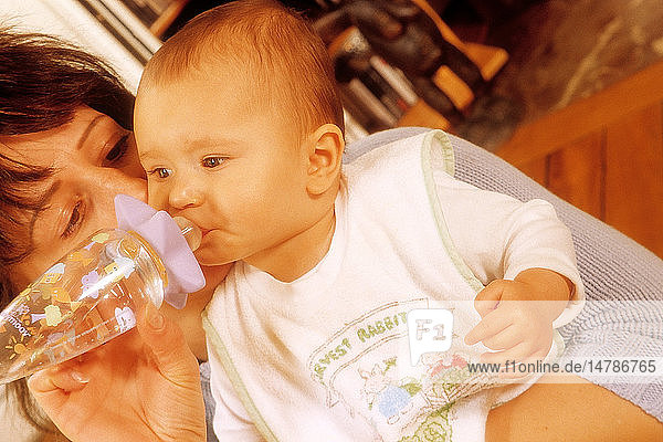 INFANT DRINKING FROM BABY BOTTLE