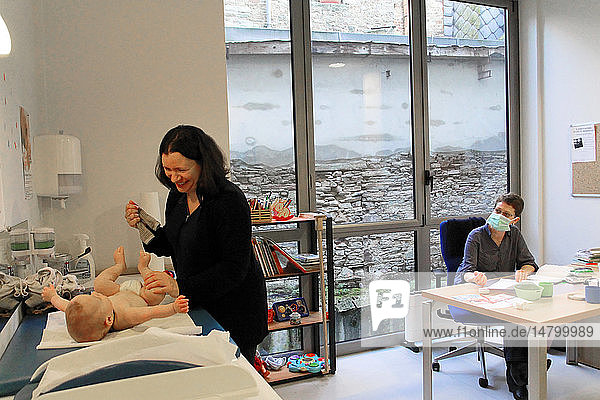 Reportage in einem französischen Mütter- und Kinderschutzzentrum in Chateaubriant  Frankreich. Konsultation mit einem Kinderarzt. Entkleiden des Kindes.
