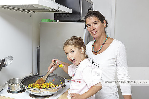 Mutter und Tochter beim Kochen.