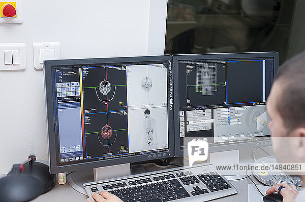 Reportage on PET imaging at the Antoine-Lacassagne Cancer centre in Nice  France. Positron Emission Tomography  or PET scan  is used in diagnosing and monitoring patients with cancer. This method enables tumours to be detected using a radioactive tracer  which accumulates heavily in cells that present a pathological hypermetabolism. The technician checks results of past exams.