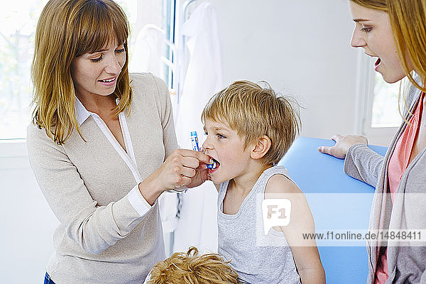 Ein Arzt gibt einem Kind Homöopathie.