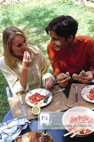 COUPLE EATING RAW VEGETABLES