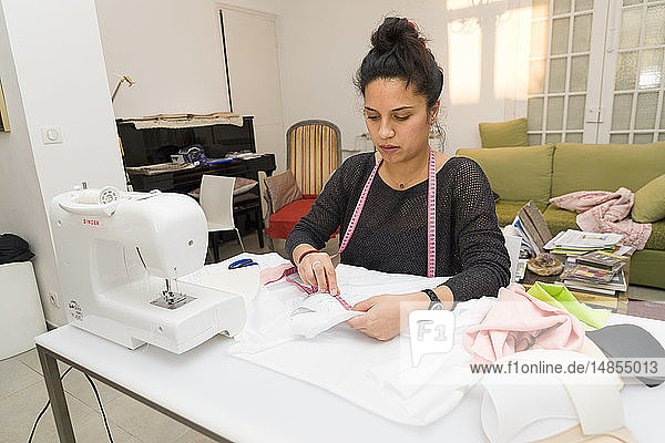 Reportage on Anne-Cecile Ratsimbason  a fashion designer for chronic patients in Nice  France. Anne-Cecile helps the patients by creating bespoke clothing and accessories that are adapted to the pathology and physical condition. She develops her prototypes at home. She is seen here working on an under garment adapted to gynaecomastia for a man whose breasts grew after several bouts of cancer.