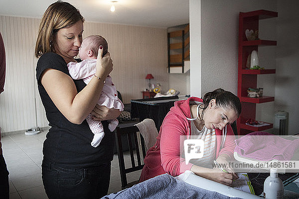 Reportage on an independent midwife during post-partum home visits. The midwife fills in the baby´s health records.