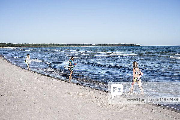 Mädchen laufen am Strand