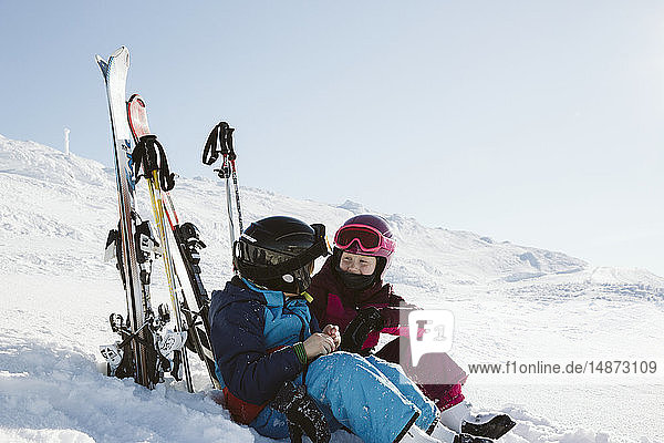Kinder ruhen sich beim Skifahren in den Bergen aus