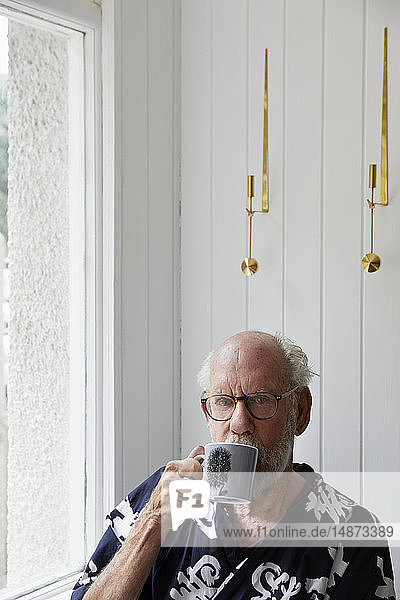 Senior man drinking from mug