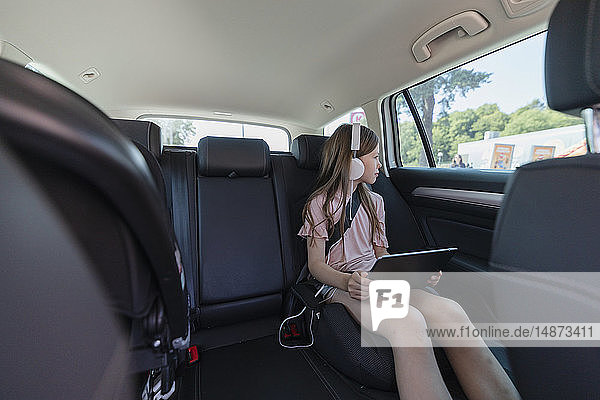 Mädchen mit digitalem Tablet im Auto