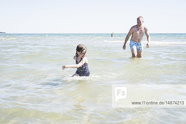 Vater spielt mit Tochter im Meer