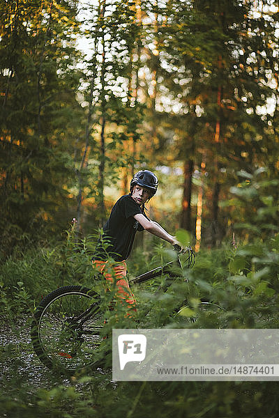Junge fährt Fahrrad im Wald