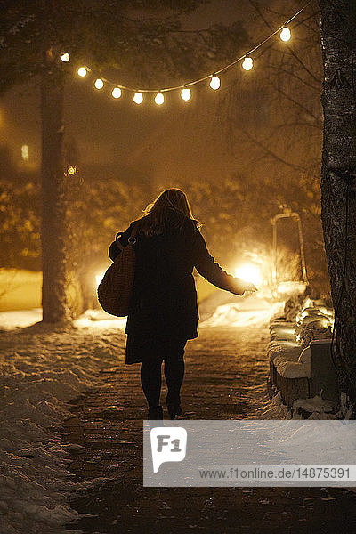 Frau beim Spaziergang in der Winternacht