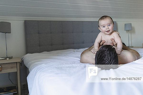 Father with baby on bed