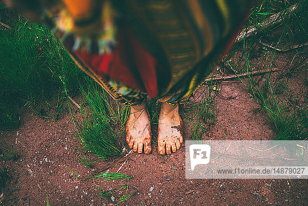 Woman standing barefoot in forest