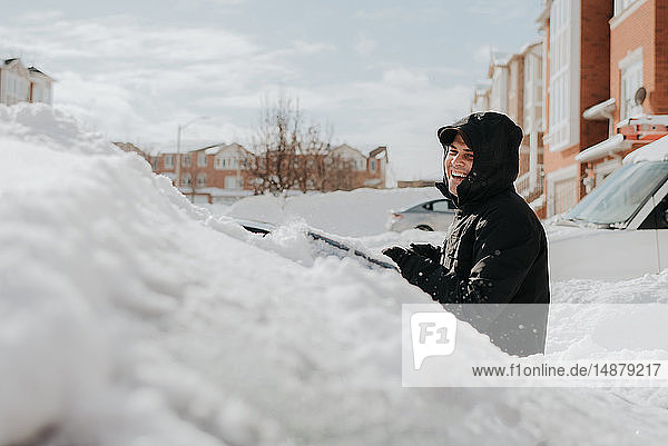 Lachender Mann neben schneebedecktem Fahrzeug,  Toronto,  Kanada