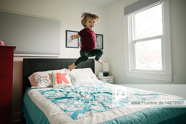 Boy jumping on bed