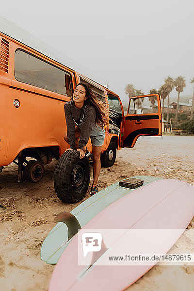 Junge Frau wechselt am Strand den Reifen eines Wohnmobils  Jalama  Kalifornien  USA