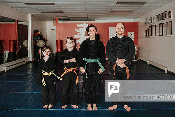 Coaches and students posing in martial arts studio
