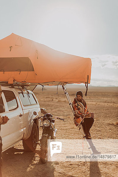 Motorradfahrer neben Zelt bewundert Motorrad  Trona Pinnacles  Kalifornien  USA