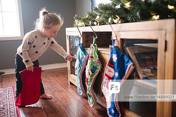 Kleinkind Mädchen hängt Weihnachtsstrümpfe auf