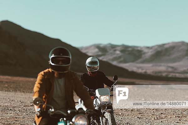 Motorcyclist friends riding in desert  Trona Pinnacles  California  US