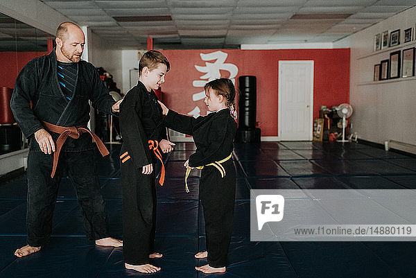Coach and students practising martial arts in studio