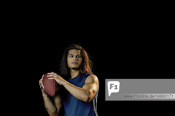 Porträt eines Fussballspielers mit Fussball  schwarzer Hintergrund