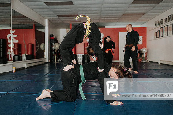Coach and students practising martial arts in studio