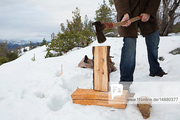 Mittelgroßer Mann beim Holzhacken auf einem schneebedeckten Berg  Twain Harte  Kalifornien  USA