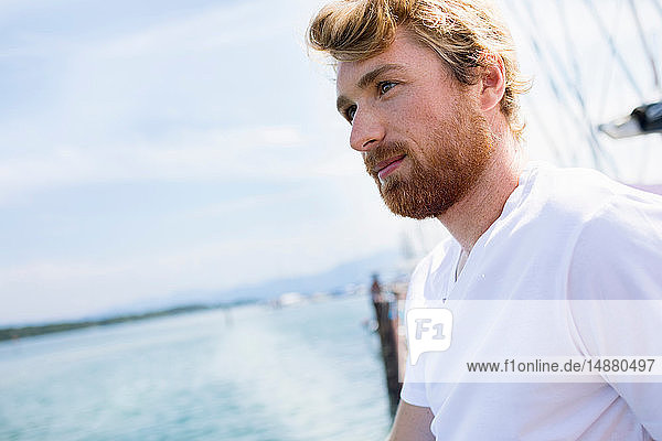 Young man on sailboat on Chiemsee lake  Bavaria  Germany