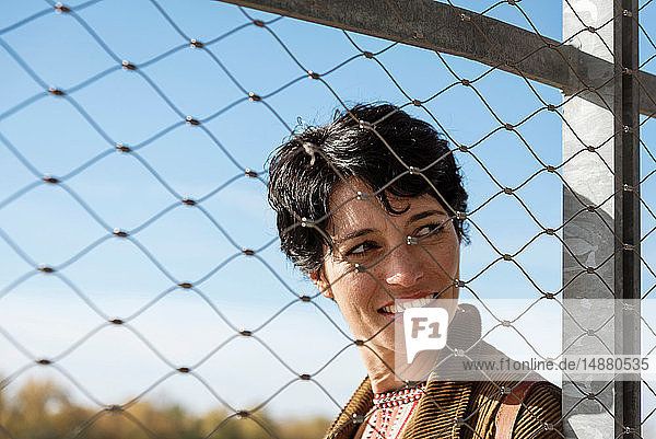 Smiling woman behind fence