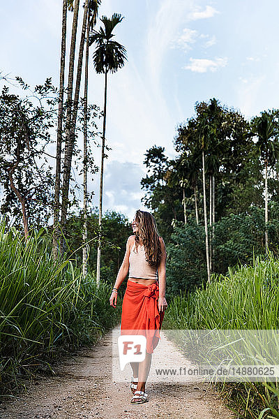 Young female tourist strolling along rural dirt track  Sri Jayawardenepura Kotte  Sri Lanka