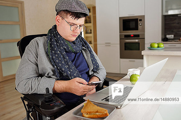 Körperlich behinderter Mann benutzt Smartphone zu Hause