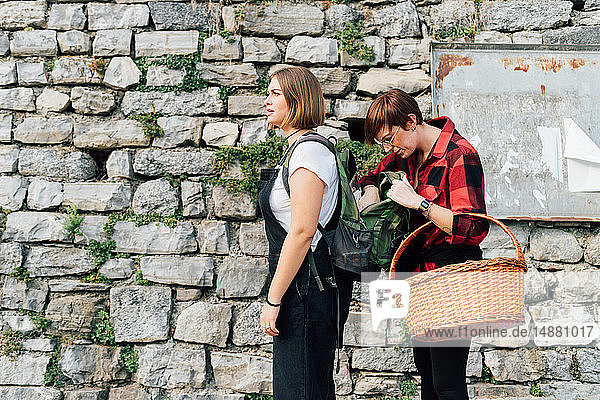 Friend looking into friend's backpack  Rezzago  Lombardy  Italy