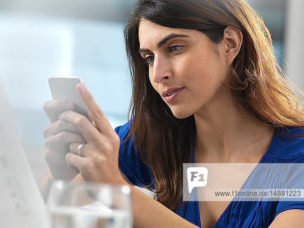 Woman using mobile phone in office