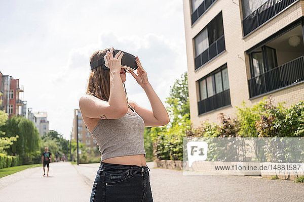 Woman using virtual reality goggles in urban Berlin  Germany
