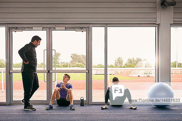 Trainer und Läufer sprechen in der Indoor-Laufbahn