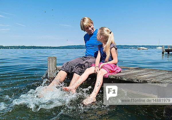 Vater und Tochter kühlen Füße im Wasser  Starnberger See  Bayern  Deutschland