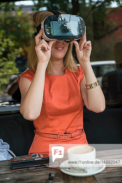 Frau benutzt Virtual-Reality-Headset im Café