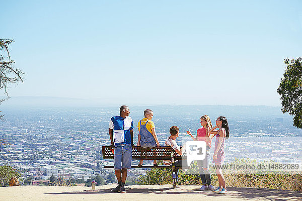 Fünf junge erwachsene Freunde auf einer Hügelbank im Stadtbild  Rückansicht  Los Angeles  Kalifornien  USA