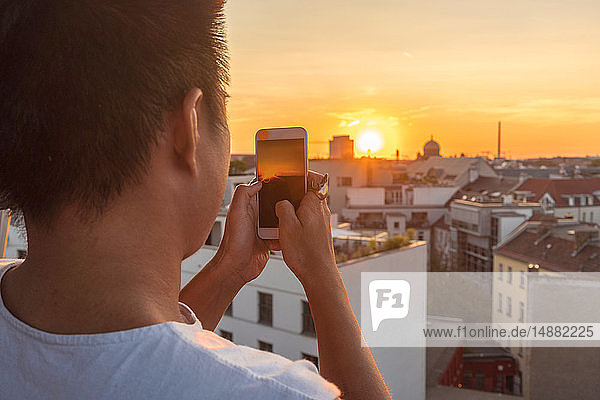 Mann fotografiert Skyline bei Sonnenuntergang  Berlin  Deutschland
