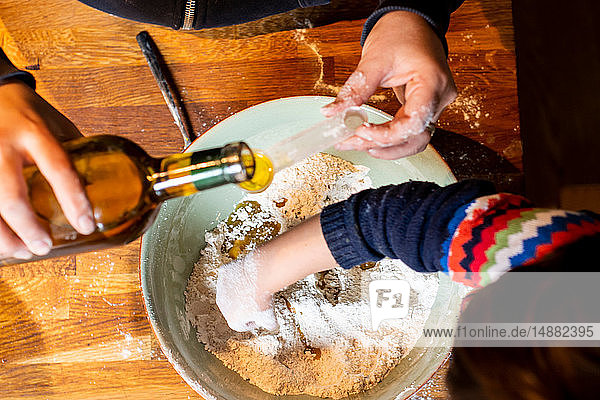 Frau gießt Öl in Mehl in Rührschüssel