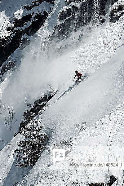 Männlicher Skiläufer rast den zerklüfteten vertikalen Berghang hinunter  Alpe-d'Huez  Rhône-Alpes  Frankreich